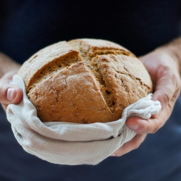 hands holding loaf of bread